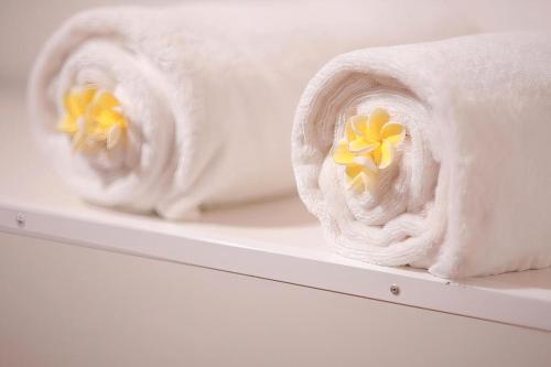 dos toallas con flores amarillas en un estante en Hotel Classio, en Digana