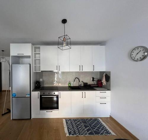 a kitchen with white cabinets and a stainless steel refrigerator at Iris Luxury Apartment in Ioannina