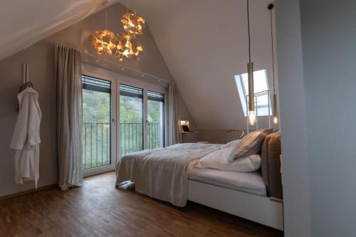 a bedroom with a bed and a large window at Freistehendes Ferienhaus Renkenmühle näher kann man am Wasser nicht wohnen in Eberbach