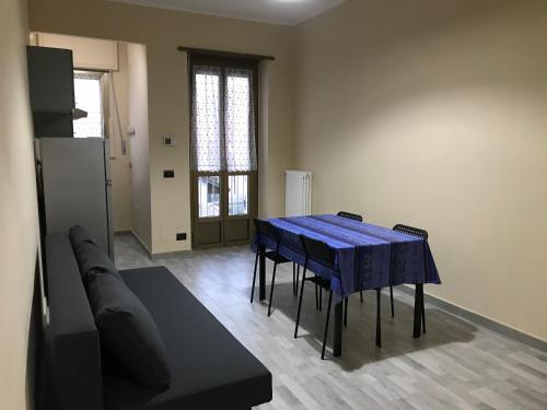 a dining room with a blue table and a couch at Il Borgo Antico: Vista su Reggia di Venaria Reale in Venaria Reale