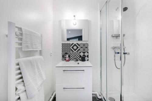 a white bathroom with a sink and a shower at Lys : Cocon Douillet proche Métro in Montrouge