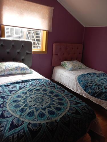 ein lila Zimmer mit 2 Betten und einem Fenster in der Unterkunft Casa cabaña My santy in Coihaique