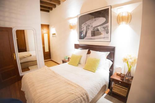 Un dormitorio con una cama y un espejo grande. en MALAVER SUITE, en Sevilla