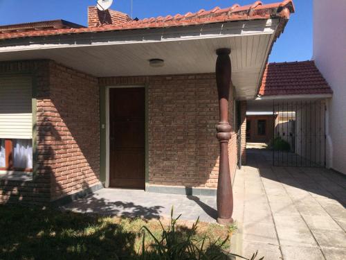 una casa de ladrillo con una puerta y un poste en La 22 en Balneario Claromecó