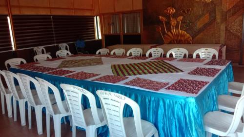 a table with white chairs and a blue and red table cloth at karthika residency in Cochin