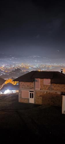 uma casa de tijolos com vista para uma cidade à noite em Čaroban pogled em Srebrenik