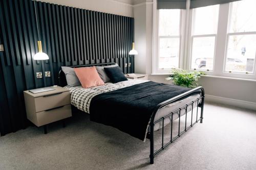 a bedroom with a bed with a black and white comforter at Sanctuary-by-Sea in Worthing