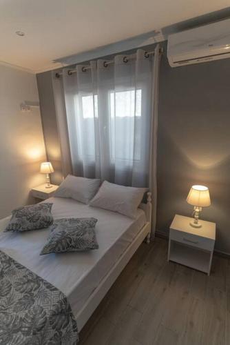 a bedroom with a bed with two pillows and a window at Studio Anna in Káto Garoúna