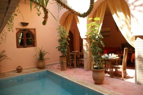 Casa con piscina y mesa con plantas en Riad Azenzer en Marrakech