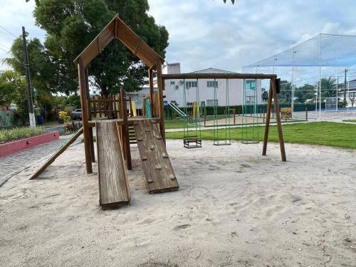 a playground with a wooden swing set in a park at Bela Casa Praia dos Carneiros Condominio Beira Mar Seg 24hrs FRENTE PISCINAS NATURAIS!!! in Praia dos Carneiros