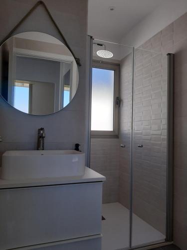 Un baño con lavabo, espejo y ducha. en Casa Argeo, en Los Llanos de Aridane