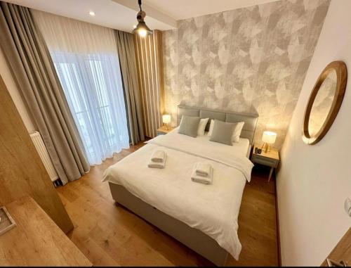 - une chambre avec un grand lit et un miroir dans l'établissement Apartman Drvorez Jahorina, à Jahorina
