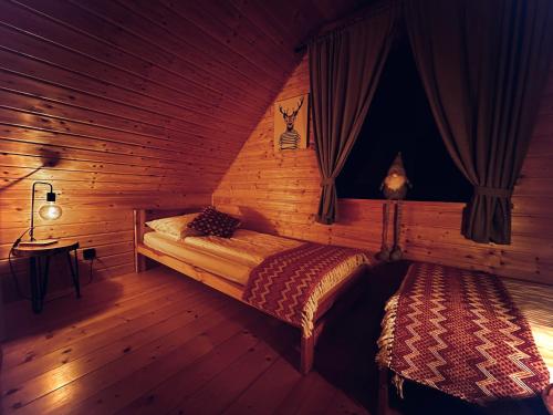 1 dormitorio con 2 camas en una cabaña de madera en Przystanek Śnieżka, en Kowary