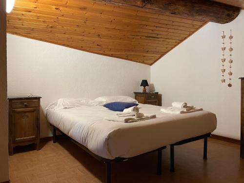una camera con un grande letto e un soffitto in legno di BOUQUE GEORGEOLINE a Rhêmes-Notre-Dame