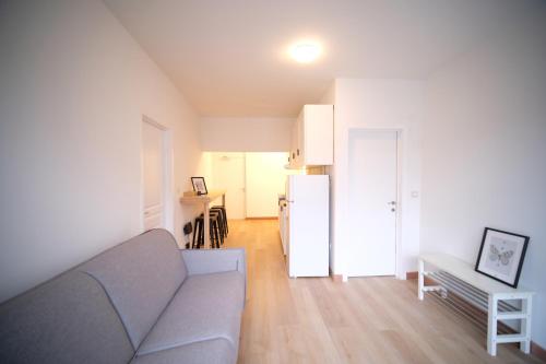 a living room with a couch and a refrigerator at Smart Appart - City Center Liege in Liège