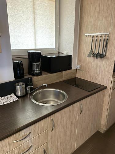 a kitchen counter with a sink and a window at Przystanek Karpacz - Apartament Roma in Karpacz