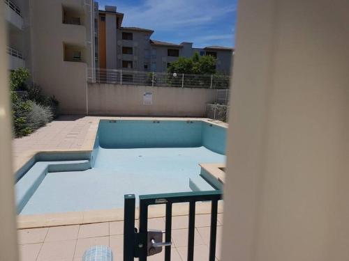 une piscine vide au milieu d'un bâtiment dans l'établissement Sympa F2 avec parking et piscine, à Montpellier