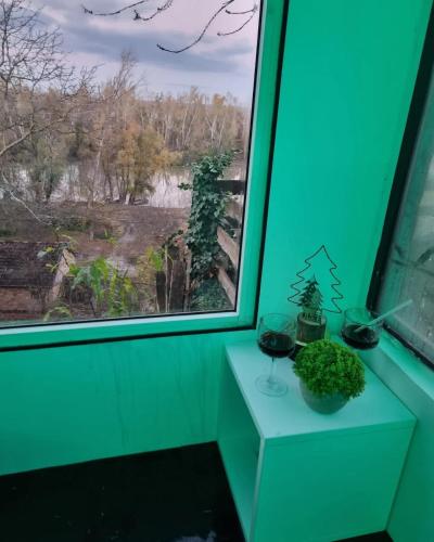 a green room with a window and two glasses of wine at Kuća za odmor Apathy in Opatovac