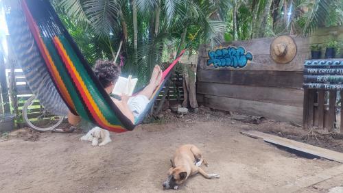un hombre tendido en una hamaca con un perro en Hostal La Buena Vida Mazunte, en Mazunte