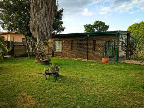 a yard with a bench in front of a house at GLESTER GUEST HOUSE in Pretoria