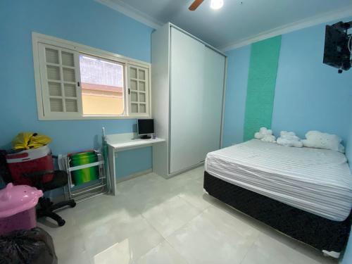 um quarto com paredes azuis e uma cama com ursos de peluche. em morada do sol em Ubatuba