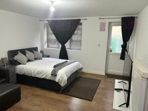 una camera con letto e finestra di Hometel Big Luxurious Self Contained Bedsit a Thornton Heath