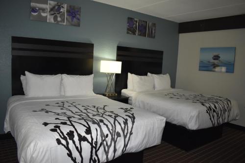 a hotel room with two beds with white sheets at Sleep Inn & Suites West Knoxville in Knoxville
