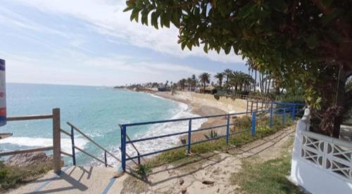 a beach with a blue fence next to the ocean at Elisenda in Vinarós
