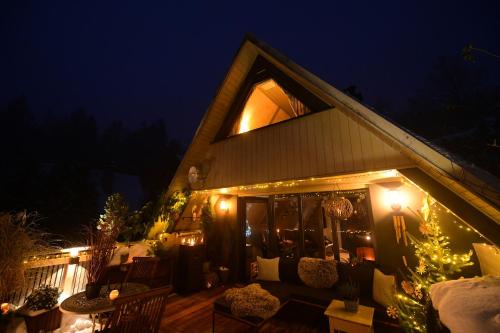 a house with christmas lights on the porch at night at Chata s wellness in Hutisko