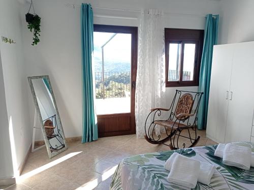 1 dormitorio con cama, espejo y silla en Apartamento Valle del Guadiaro, en Cortes de la Frontera