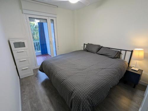 1 dormitorio con 1 cama y puerta a un balcón en Bruselas 23, en Alicante