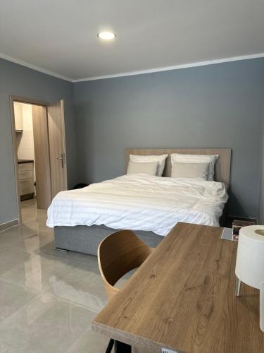 sypialnia z łóżkiem i drewnianym stołem w obiekcie VuVista w Pradze