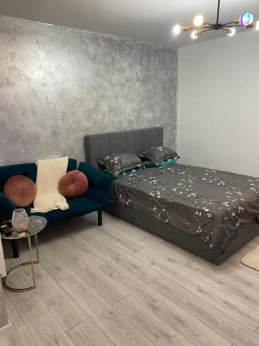 een slaapkamer met een bed en een blauwe bank bij Sofi Studio Central in Boekarest