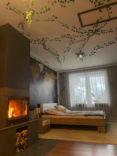 - une chambre avec un lit et une cheminée dans l'établissement Dom w górach z kominkiem i balią ogrodową Sielanka, à Skomielna Czarna