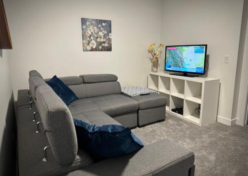 a living room with a couch and a flat screen tv at Entire4BedroomHomeKingParkingKitchenWasherDryerFastWiFi in Calgary
