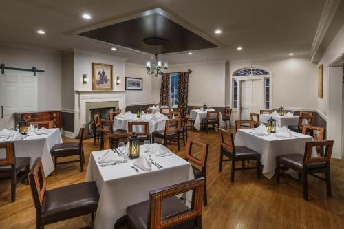 a dining room with tables and chairs and a fireplace at Sheraton Great Valley Hotel in Frazer