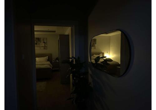 einen Spiegel in einem Zimmer mit einem Schlafzimmer und einem Bett in der Unterkunft شقة تتكون من صالة وغرفة ومطبخ, حي النرجس in Riad