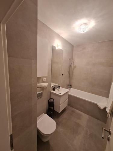La salle de bains est pourvue de toilettes, d'un lavabo et d'une baignoire. dans l'établissement MV Residence Brasov, à Braşov