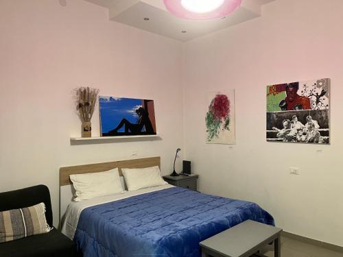 a bedroom with a blue bed and a couch at Casa Cirenaica Art House in Bologna