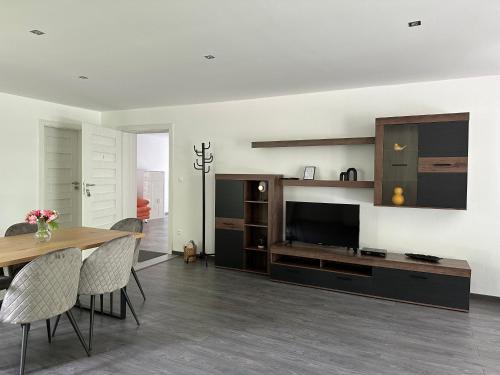 a living room with a dining table and a television at Riverside Residence in Trstice