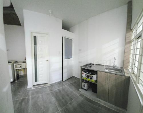 a white kitchen with a sink and a counter at FAMILY HOUSE CN in Cali
