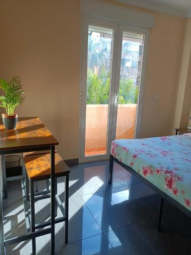 a room with a bed and a table and a table sidx sidx sidx at Habitaciones Centricas en una casa Valenciana in Valencia