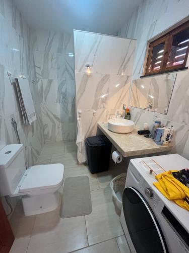 uma casa de banho branca com um WC e um lavatório em Villa Amarelo em Beberibe