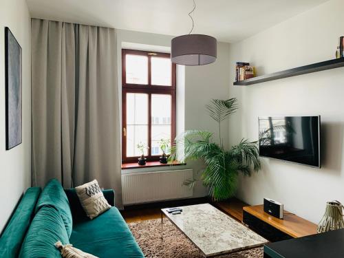 a living room with a green couch and a window at Apartament ST2 in Cieszyn