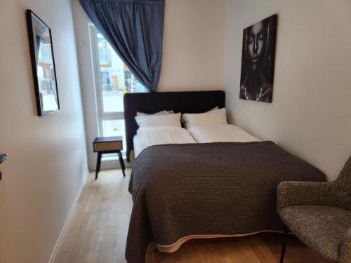 1 dormitorio con 1 cama, 1 silla y 1 ventana en Gjerdrum/ Oslo apartment for your trip/holiday en Gjerdrum