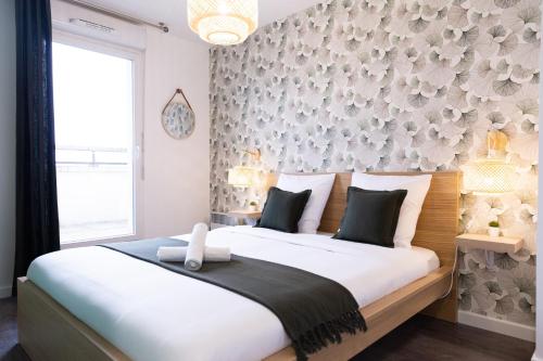a bedroom with a large bed and a wall with flowers at Suite Familiale, Disneyland Paris, 8 personnes in Montévrain