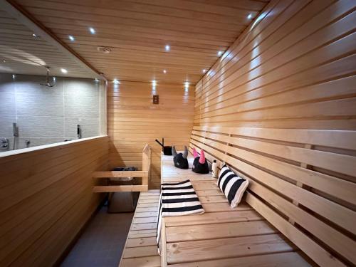 a sauna with two cats sitting on a bench at Linnunvilla with sauna in Rovaniemi