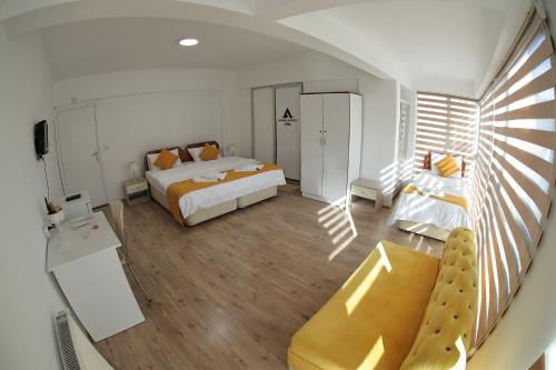 にあるARDA AKSOY OTELのベッド2台とソファが備わる広い客室です。