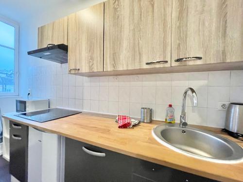 a kitchen with a sink and a counter top at LA PASSERELLE 2G - Quartier Gare - Wifi - Parking in Quimper