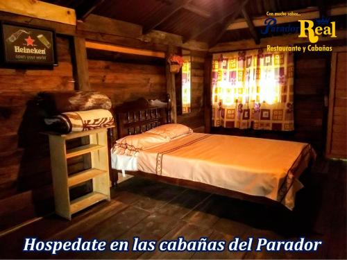 um quarto com uma cama num chalé de madeira em Parador Real cabañas 